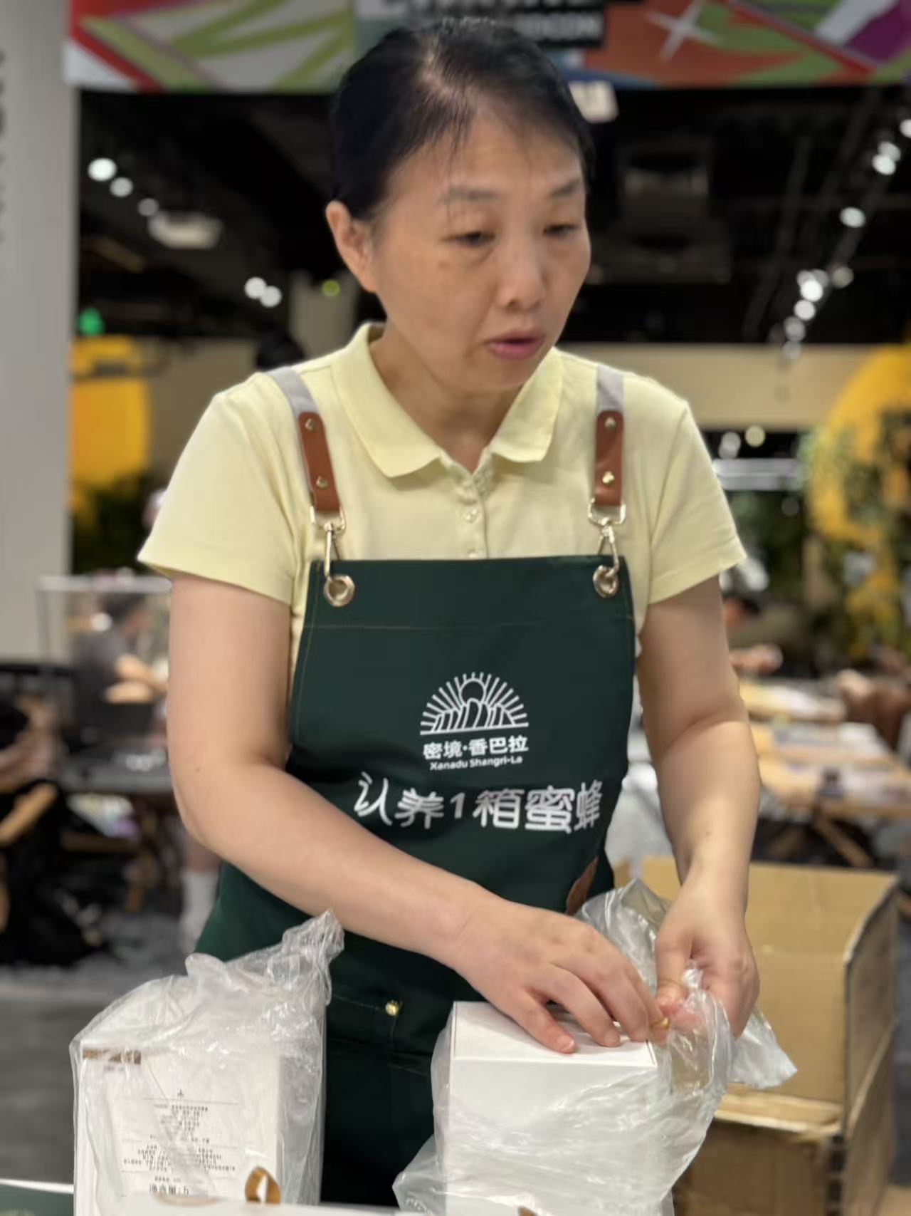 Volunteer packing honey gift boxes at the booth