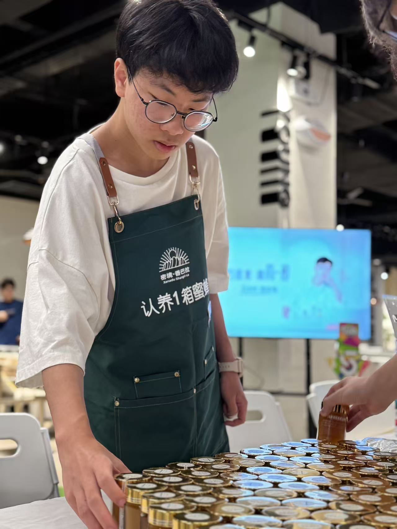 Volunteer arranging honey jars on the charity-sale table